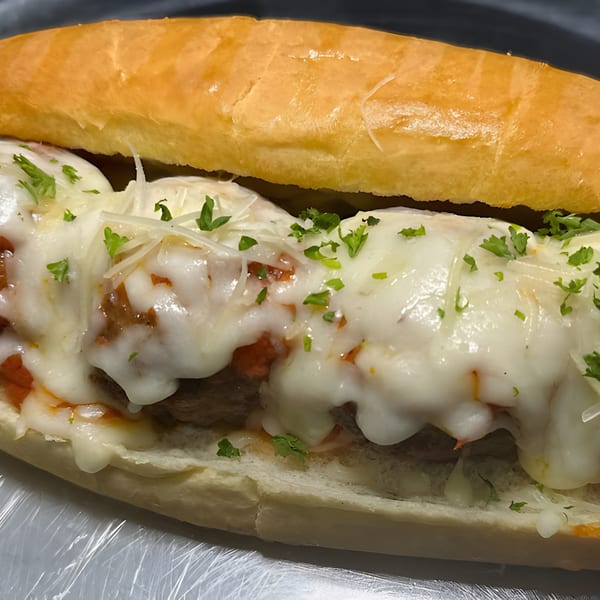 A meatball sub from Slice Brunswick, topped with melted mozzarella, parmesan, and fresh parsley.
