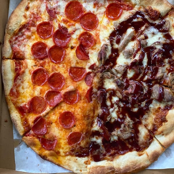 A half pepperoni, half BBQ chicken pizza from Slice Brunswick, in a cardboard box.
