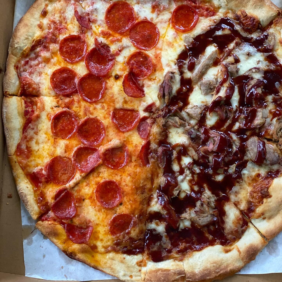 A half pepperoni, half BBQ chicken pizza from Slice Brunswick, in a cardboard box.